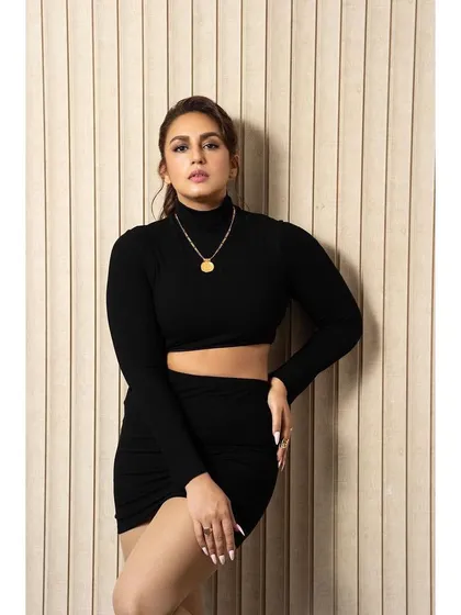 A chic black long-sleeve crop top and skirt set by Superdown. It's a modern and edgy look, perfect for a promotional event or a stylish party.