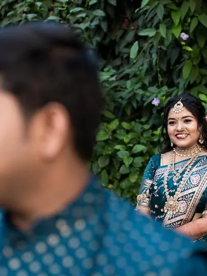 Creative focus can add a layer of storytelling to an image. By focusing on the bride's smiling face in the background, the groom in the foreground becomes a framing element, creating a sense of perspective and depth in this candid couple portrait.