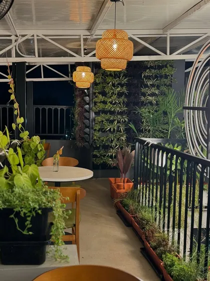 A rooftop cafe at night, where our vertical gardens and planters create a lush, inviting atmosphere. The warm lighting and dense greenery transform the space into an intimate and serene urban escape.