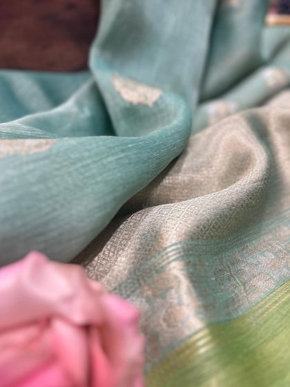 The soft, flowing drape of a Tissue Silk saree. The focus is on the fabric's texture and its gentle sheen, illustrating why it is a preferred choice for elegant occasions.