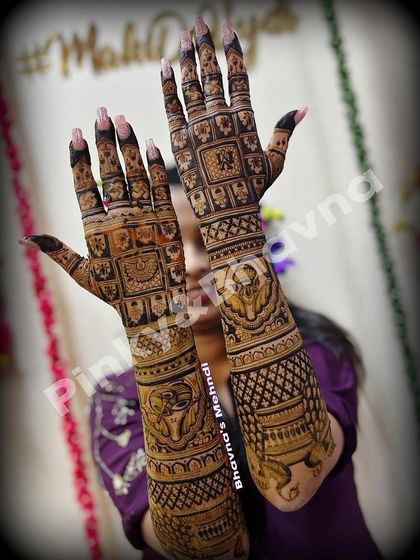 A beautiful example of full coverage bridal mehndi. The design features classic square patterns, elephant motifs, and delicate floral work that extends all the way up the arms for a truly grand statement.