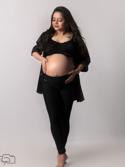 A beautiful and raw bare-bump portrait. The simple black lingerie and open shirt create a modern, confident, and intimate look.