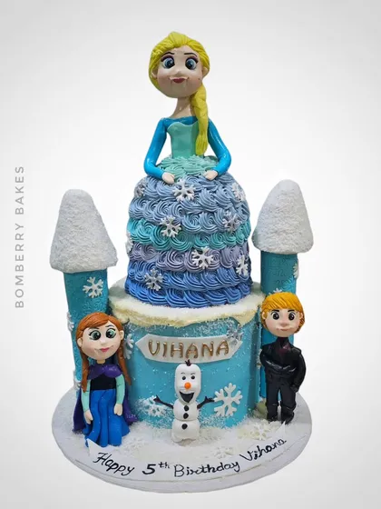 A 3kg Belgium chocolate truffle cake with a Frozen theme, featuring a sculpted Elsa doll, castle turrets, and figurines of Anna, Kristoff, and Olaf.