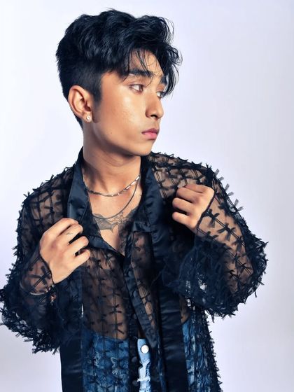 This shot plays with texture and transparency. The sheer fabric and the model's tattoos create a layered, edgy look.