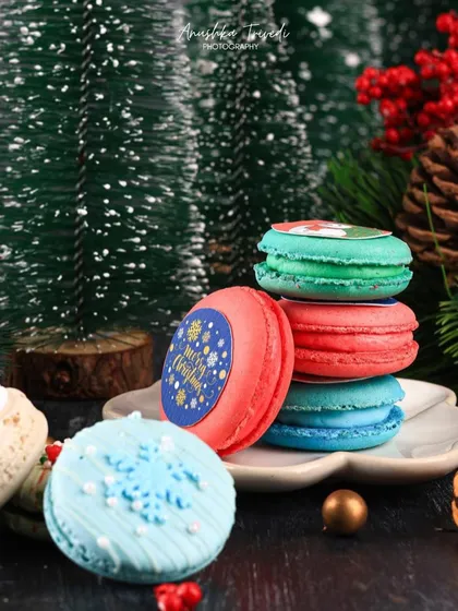 The Christmas macarons styled in a wider shot with miniature pine trees. This gives the photo a lovely sense of scale and a festive forest feel.
