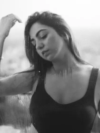 A black and white photo with a rain-on-the-window effect, creating an artistic and moody portrait.