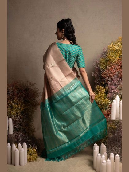 A beautiful Kanjivaram in pastel peach and green, paired with an embroidered blouse, showcasing a soft and elegant look.