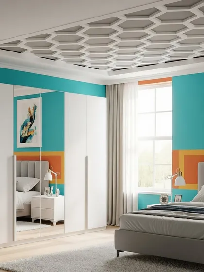 A contemporary bedroom with a bold color scheme, featuring a geometric honeycomb pattern on the false ceiling. The white, multi-door wardrobe includes a mirrored panel that reflects the room's colorful decor.