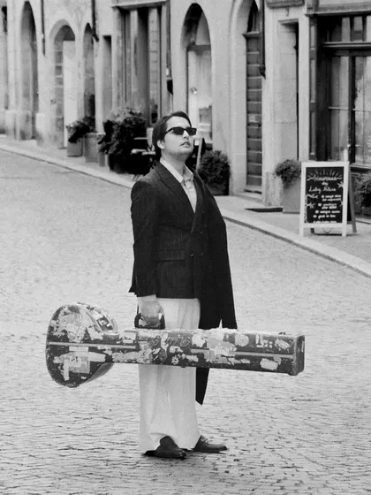 Strolling through old-town Lausanne. This black and white shot captures the timeless feeling of carrying a traditional instrument through historic European streets.