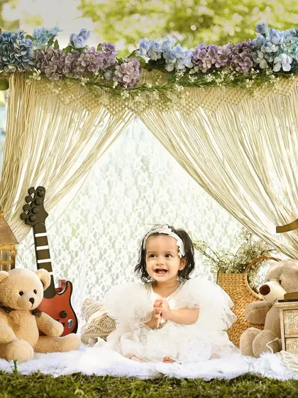 A sweet smile from our little rockstar. The combination of a guitar, teddy bears, and a beautiful floral and macrame backdrop creates a unique and charming boho-chic vibe.
