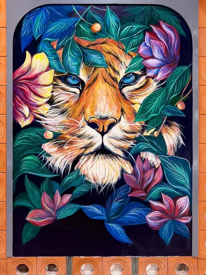 The full view of the tiger mural panel in Uttarakhand, framed by the restaurant's terracotta brick wall.