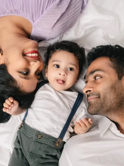 A unique perspective for a family photo. Lying down together creates a fun, intimate, and relaxed portrait, with the baby as the adorable center of attention.