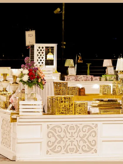 A close-up of our detailed buffet station decor. Intricately designed white counters are paired with golden accents and ambient table lamps to create a luxurious feel.