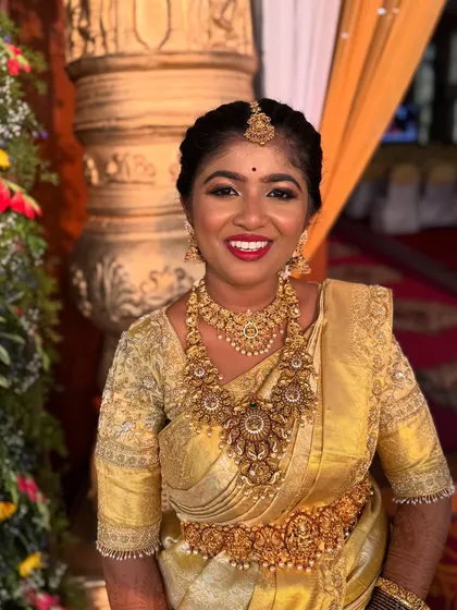 A radiant bride ready for her muhurtham. The classic combination of a golden Kanjeevaram saree, temple jewellery, and my signature glowing makeup with a bold lip creates a truly timeless and traditional bridal look.