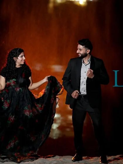 A "filmy" dance moment at night, with the couple dressed in black. The dramatic lighting and their poses create a very cinematic and elegant pre-wedding photo.