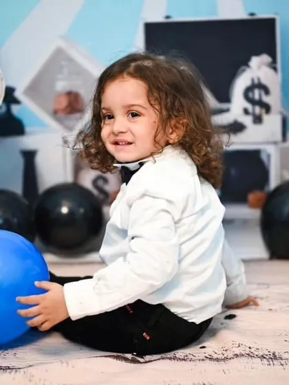 A candid shot from a Boss Baby photoshoot. The set includes a prop briefcase full of fake money and a backdrop that mimics the movie's style, ensuring every photo fits the theme.