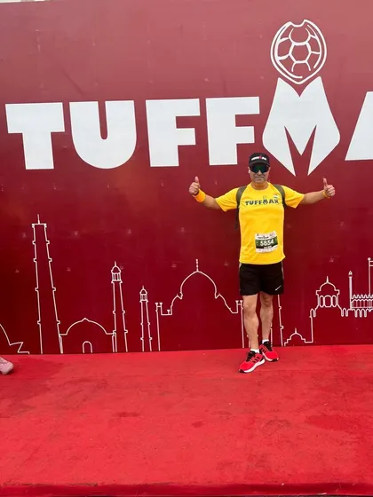 A member giving a thumbs up at the Tuffman finish line. Another race conquered, another medal earned.