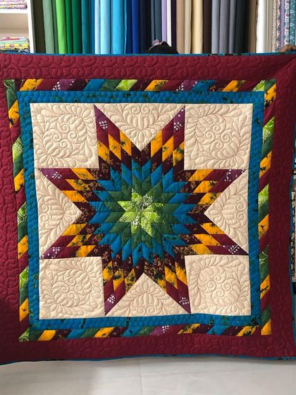 A vibrant Glowing Star quilt with a beautiful gradient of colors.