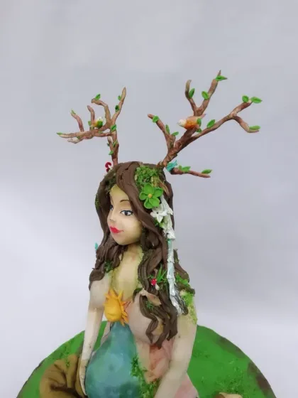 A profile view of the Mother Earth figurine, showing the small birds and flowers in her hair. These tiny details are what bring a complex piece like this to life.