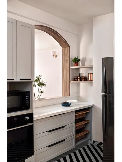 And here is the calm after the chaos. The same kitchen, now transformed into a clean, functional, and serene space. With light grey cabinetry, an arched pass-through to the dining area, and smart storage solutions, it’s a testament to how structural changes can bring light, flow, and a completely new energy to the heart of the home.