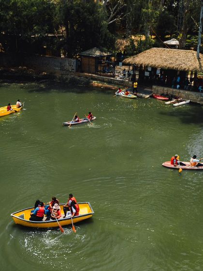 An aerial view of the bustling lake, with kayaks, boats, and people enjoying the water activities near the dock.