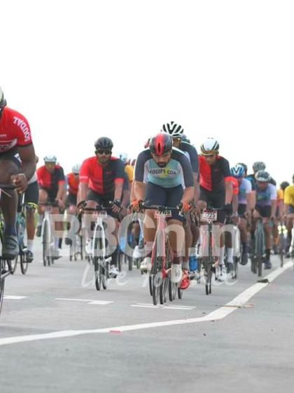 The elite peloton, a long line of riders stretching down the road.