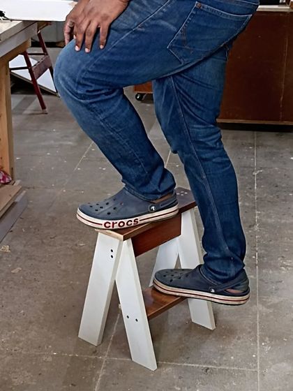 Testing the strength of the step stool. Despite being made from scrap material and simple joinery, it's more than strong enough to support an adult's weight.