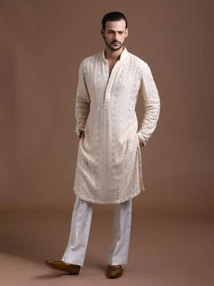 An off-white embroidered kurta paired with classic white trousers. This is a versatile and elegant choice for any occasion, blending tradition and trend seamlessly.