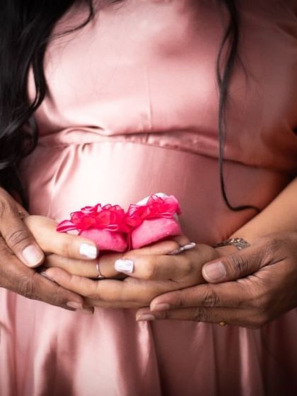 Another beautiful detail shot, this time with a pair of bright pink baby booties. These close-ups are a lovely way to announce you're expecting a girl.