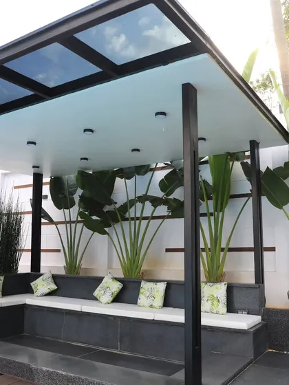 A close-up of the gazebo's interior, showing the built-in seating and the frosted glass roof panels that provide shade while keeping the space bright. The design is both practical and stylish.