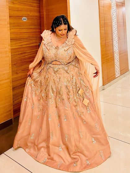 A client having her Cinderella moment in a beautiful peach gown with a cape. This plus-size friendly outfit is perfect for making a grand entrance at any event.