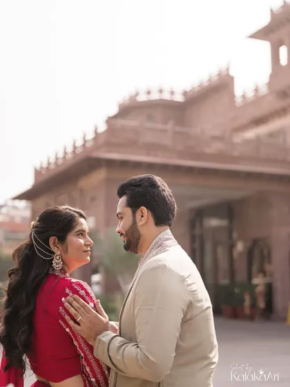 A beautifully composed portrait with the couple in the foreground and the magnificent hotel architecture behind them.