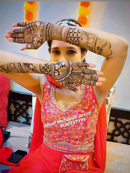 A happy client showing off her bridal mehandi. The back-hand design is just as intricate as the front, ensuring a complete look.