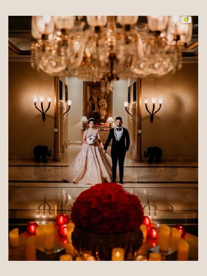 A masterpiece in a palace. For this reception, I used a simple yet powerful combination of a large red floral centerpiece and surrounding candles to create a dramatic and romantic focal point under the magnificent crystal chandelier.
