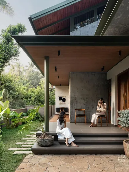 A covered verandah provides a perfect indoor-outdoor living space, looking out onto the lush garden.