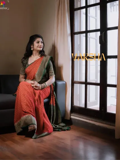A pensive bridal portrait by the window. The natural light creates a soft, painterly effect, highlighting the bride's elegance in her simple yet beautiful saree.