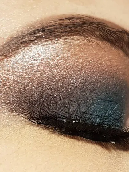 A side view of the teal smokey eye. This angle shows how the false lashes add volume and length, completing the dramatic eye makeup look.
