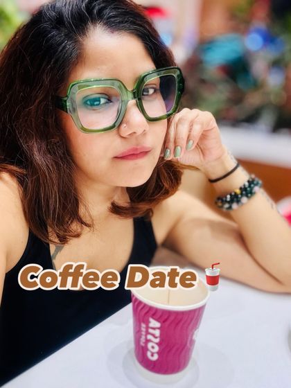 A coffee date look. The simple black tank top is accessorized with bold green glasses, adding a fun and personal touch to a classic outfit.