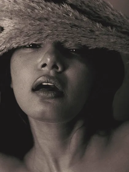 A bold and unconventional composition in black and white. The pampas grass covers the top of the model's face, drawing all attention to her mouth and expression. It's an artistic and intriguing shot.