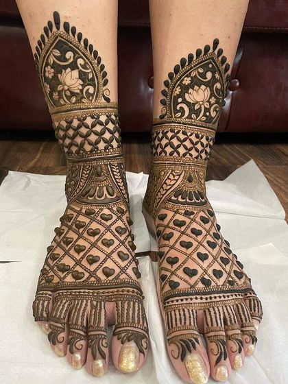 A lovely foot design featuring a jaali pattern made of hearts, perfect for a bride. The design extends up the leg with lotus motifs and traditional borders.