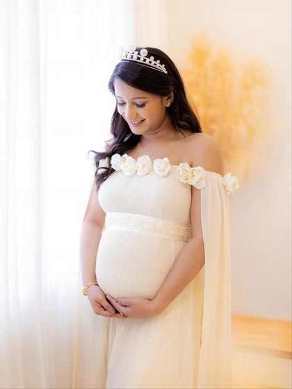 A portrait of a queen. The addition of a simple tiara to this angelic white gown makes the mom-to-be look and feel like royalty.