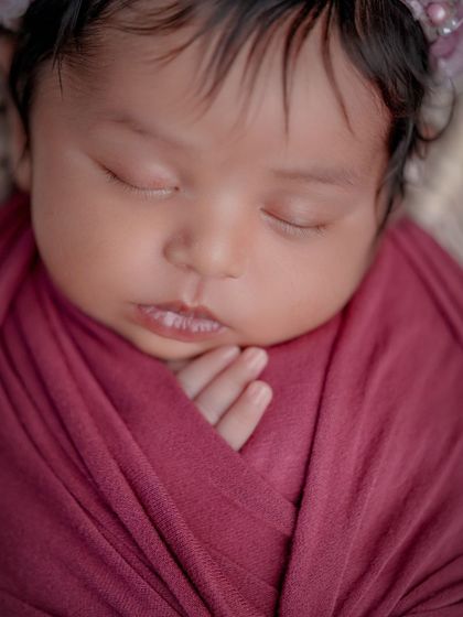 A close-up on pure innocence. This tightly cropped photo of a swaddled baby highlights their perfect lips and tiny hand, details you'll want to remember forever.
