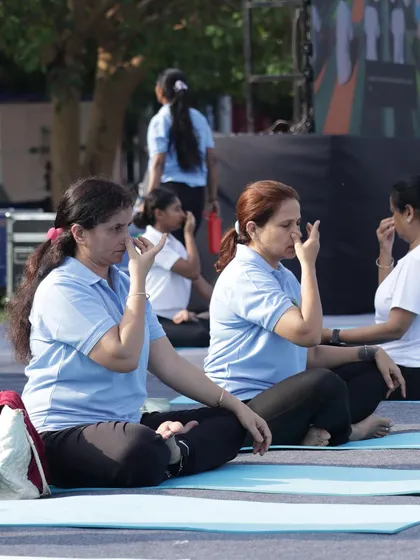 Participants at a corporate event practicing Nadi Shodhana pranayama, a technique perfect for improving focus before a conference or meeting.