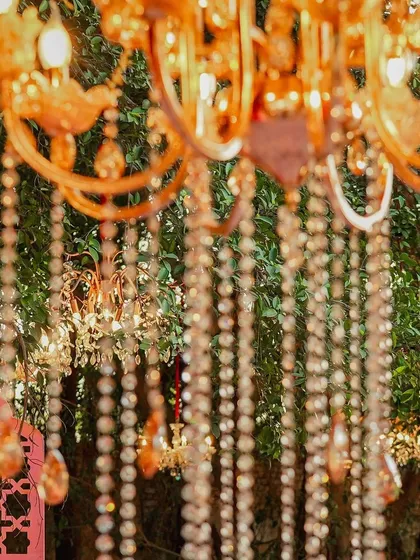 A dreamy, soft-focus shot of a crystal chandelier, highlighting the way it sparkles and adds a touch of elegance even to a daytime, outdoor event.