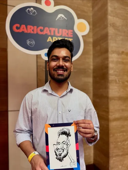 A happy guest holding his caricature at the Fractal25 corporate celebration. These events are filled with smiles, laughter, and art.