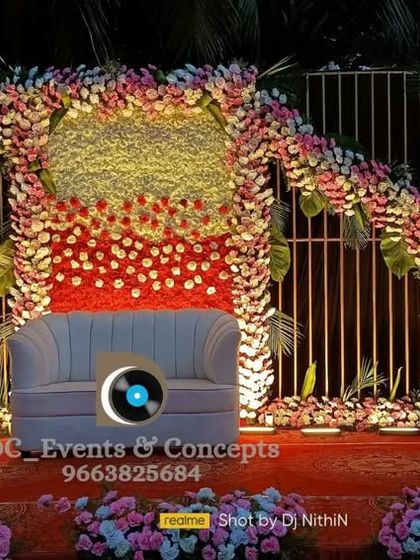This Mehendi decor features a unique arched structure covered in dense, colorful flowers. The design creates a vibrant and festive backdrop, perfect for celebratory photos.