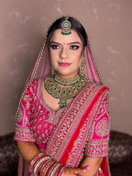 A closer look at this bride's soft and pretty-in-pink makeup. The focus is on a flawless base, gentle color on the eyes and cheeks, and a lip color that complements her outfit perfectly.