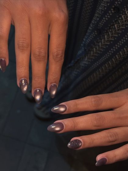 A still shot of the dark, moody cat-eye nails. The magnetic polish creates a sharp line of light that moves as your hand does.