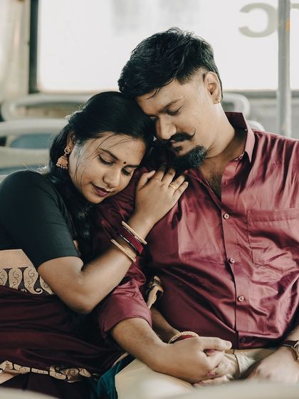An intimate moment inside a bus, the bride resting her head on the groom's shoulder, creating a peaceful and romantic scene.