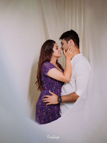 A close and intimate embrace, framed by soft white curtains.